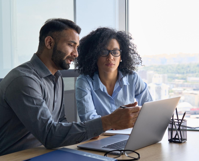 Two people in office working together at laptop