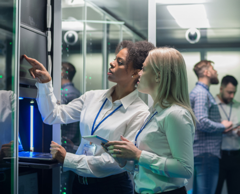 Side view of two engineers in server room