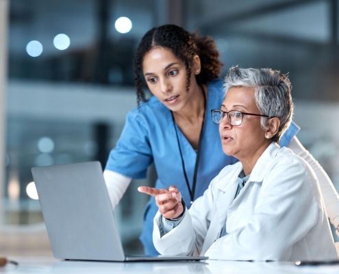 Healthcare workers in office looking at laptop